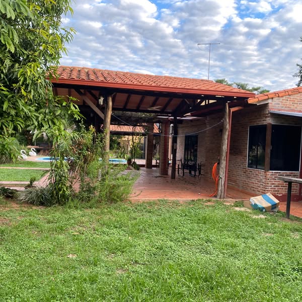 Patio arbolado, quincho y piscina de la casa en barrio cerrado Ytororó